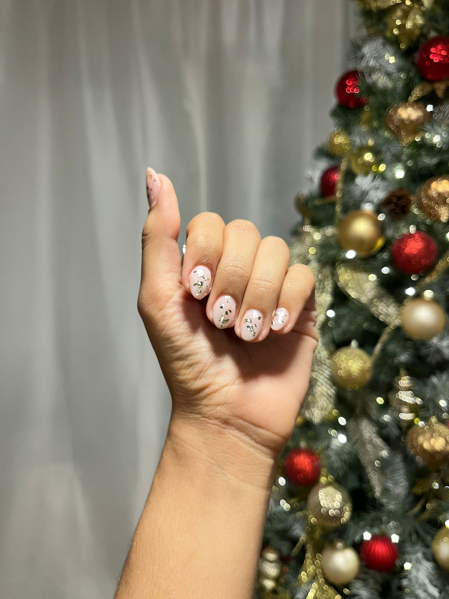 Acrylic nail manicure with golden flakes.